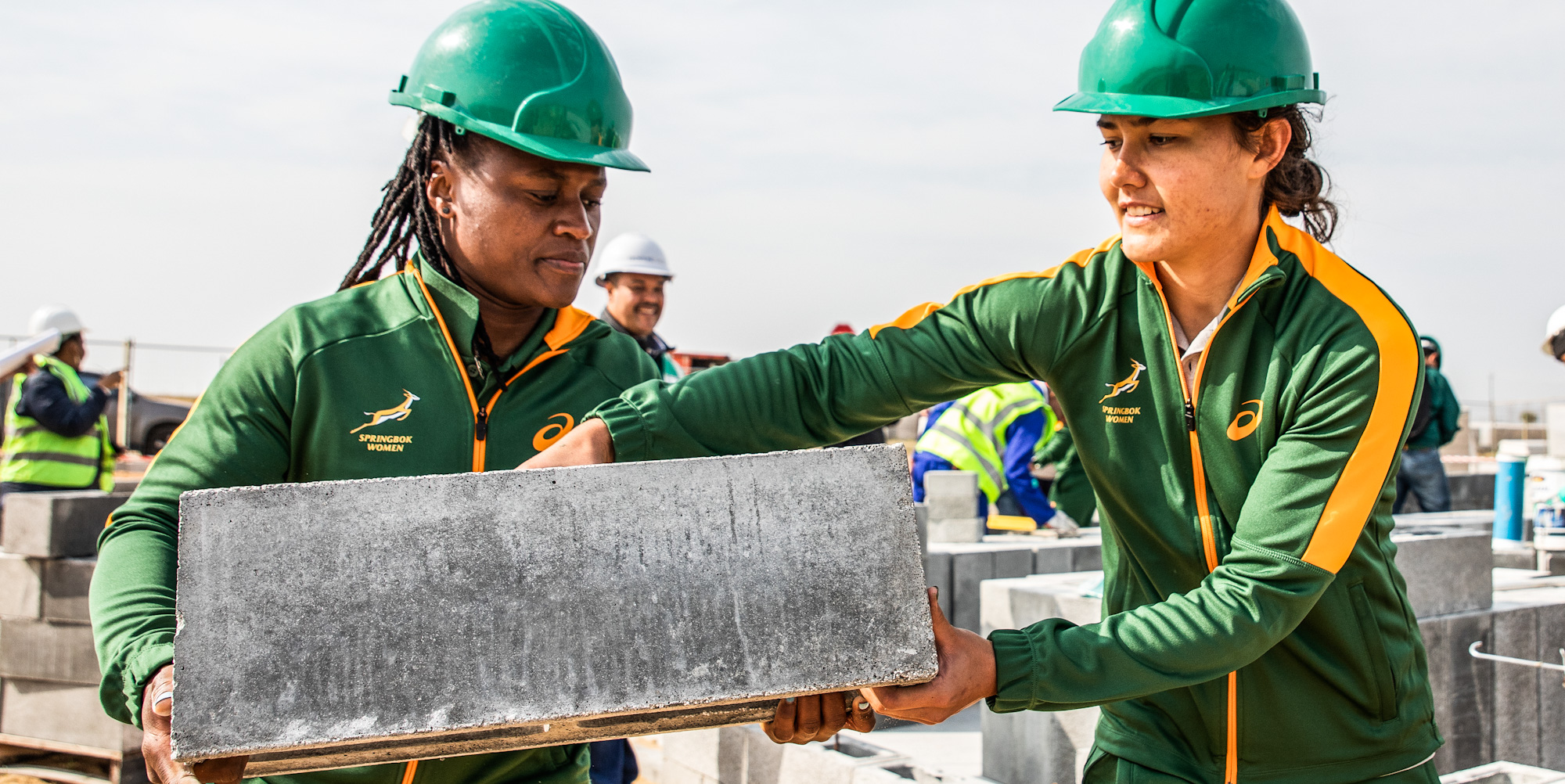 Zintle Mpupha and Kirsten Eastes getting their hands dirty helping to build houses.